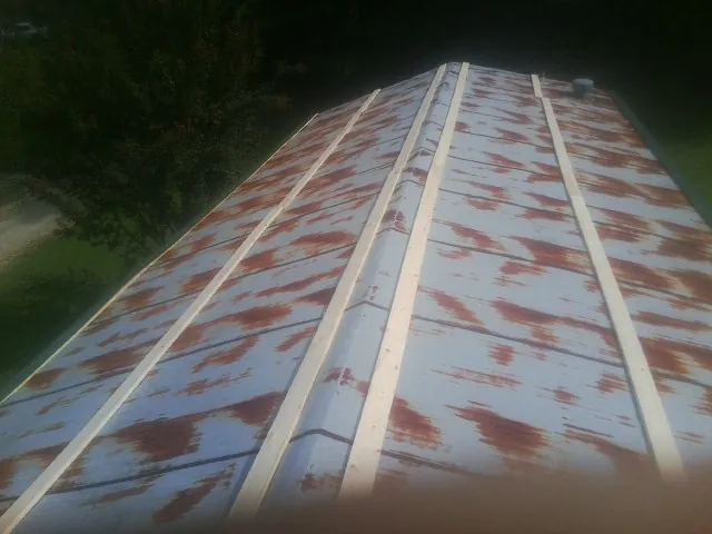 Rusted metal roof panels with new wood purlins before replacement — Storm Damage Roof Repair in Austinburg by Roofing Brothers